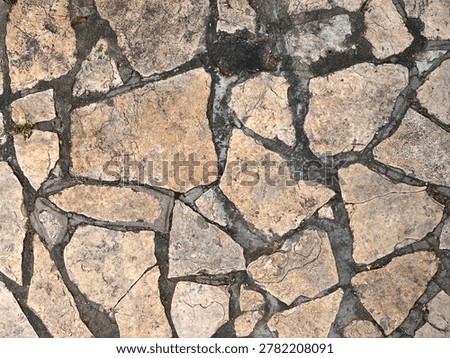 Old irregular stone pavement texture with weathered surface. 