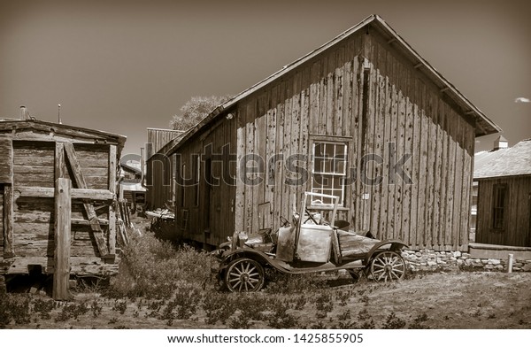 old jalopy in front of a\
wooden shed
