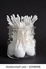 An Old Jar Filled With Cotton Balls And Swabs