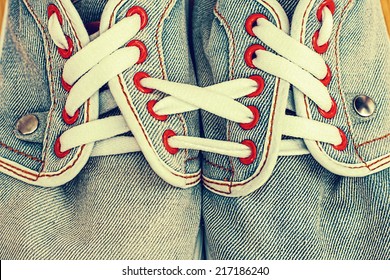 Old jeans sports shoes laced unusually - Powered by Shutterstock