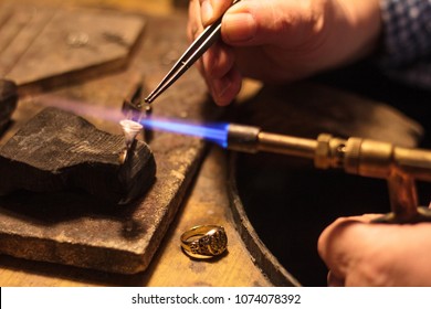 Old jeweler at work on his studio 
