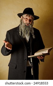 Old jewish man with grey beard holding a book