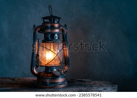 The old kerosene lamp on a wooden floor, old gray cement backdrop.