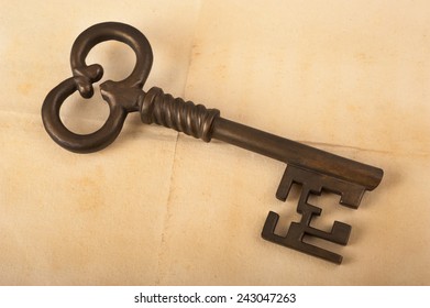 Old key on an antique parchment background