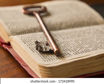 an old key on top of an old Bible