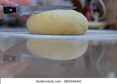 Old Lady Chef Is Cutting Homemade Fresh Dough With Knife, With Reflection On The Marble Counter Top. She Is Making Dumplings And Gnocchi.