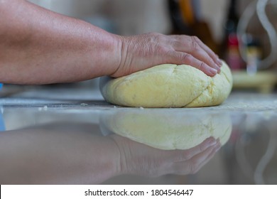 Old Lady Chef Is Kneading Homemade Fresh Dough With Knife, With Reflection On The Marble Counter Top. She Is Making Dumplings And Gnocchi.