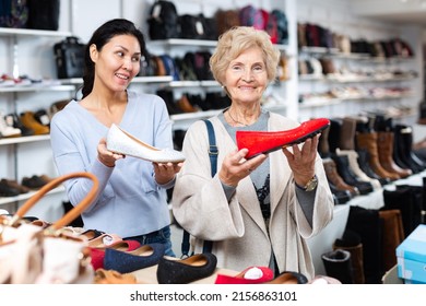 Old Lady Choosing New Shoes In Shoeshop. Asian Woman Consulting Her About Footwear.