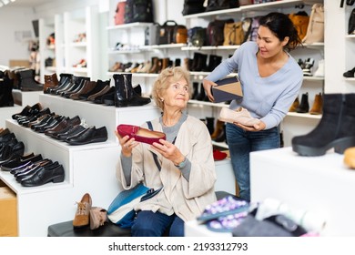 Old Lady Choosing New Shoes In Shoeshop. Asian Woman Consulting Her About Footwear.