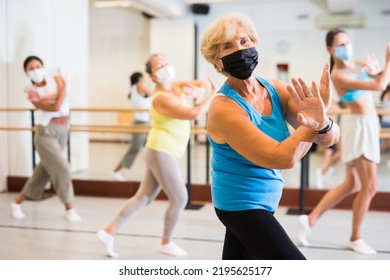 Old Lady Dancing With Other Women In Face Masks During Group Training In Studio.