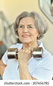 Old Lady Exercising In A Gym With Dumbbell