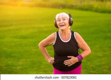 Old lady with headphones. Woman smiling outdoors. New hits on the radio. Music brings charge of energy.