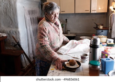 Old Lady In The Kitchen Of The Old House In The Village. The Granny Is Starving. Lonely Elderling.