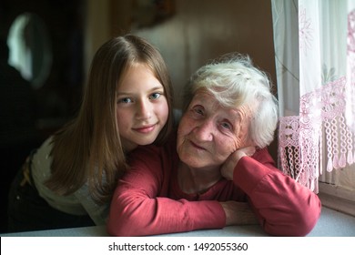 Old Lady Posing For A Portrait With Little Girl Great-granddaughter.