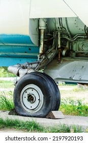 Old Landing Gear Of A Military Aircraft. Fragment Of Shock Absorber And Air Transport Wheel. Vertical Photo. Close-up