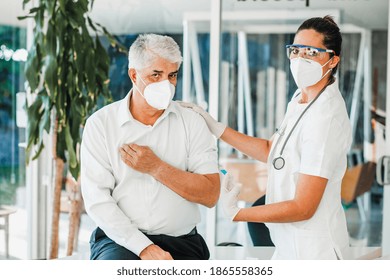 Old Latin Man Receiving Vaccine Shot For A Mexican Doctor Woman With Facemask For Coronavirus Pandemic In Mexico City