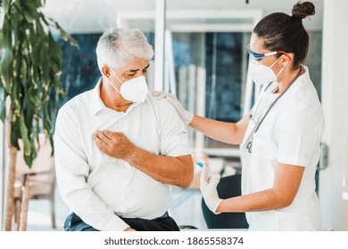 Old Latin Man Receiving Vaccine Shot For A Mexican Doctor Woman With Facemask For Coronavirus Pandemic In Mexico City