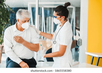 Old Latin Man Receiving Vaccine Shot For A Mexican Doctor Woman With Facemask For Coronavirus Pandemic In Mexico City