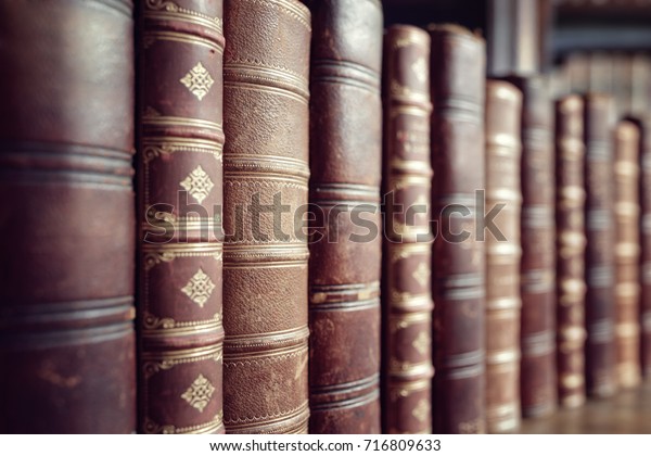 Old leather bound\
vintage books in a row