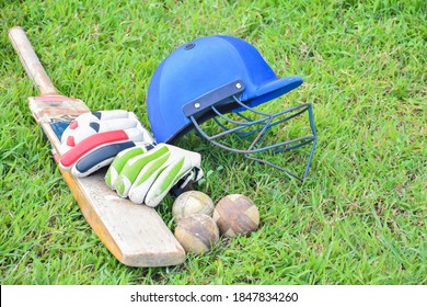 Old leather cricket ball and cricket sportwears on the green grass court, concept for practicing cricket sport after school of Asian students.  - Powered by Shutterstock