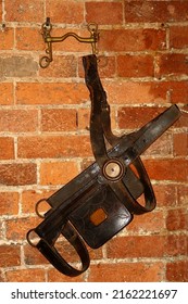 An old leather Harness hanging from a wall