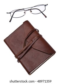 Old Leather Journal With Simple Black Glasses Isolated On White With A Clipping Path.