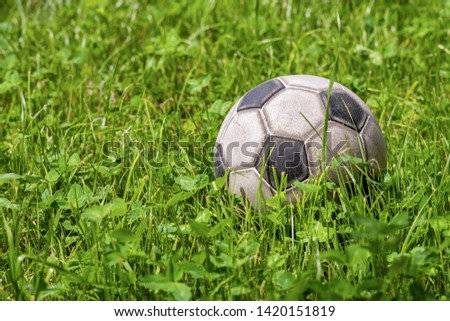 Old leather soccer ball on green grass with copy space, football sport concept