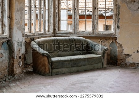 An old leather sofa in an abandoned place.