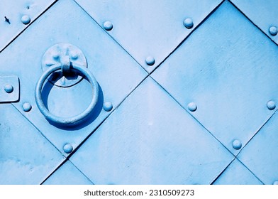 Old light blue door with rivets and aged metal door handle in the form of ring. Textured vintage background.  - Powered by Shutterstock