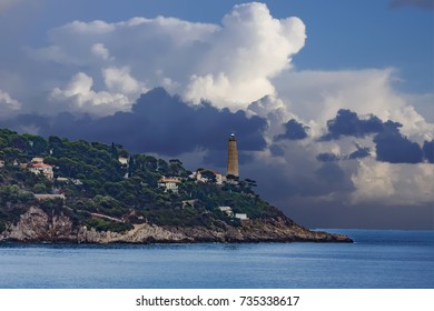 An old Lighthouse on Point Under Storm Clouds