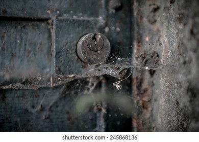 An old lock between dust and cobwebs.