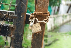 Old Lock And Rusty Lock Chain Hangs On A Old Metal Gate