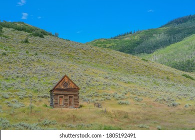 Old Log Cabin, Abandoned In The Country Hillside Of Rocky Mountains In Colorado