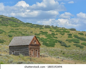 Old Log Cabin, Abandoned In The Country Hillside Of Rocky Mountains In Colorado