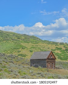 Old Log Cabin, Abandoned In The Country Hillside Of Rocky Mountains In Colorado