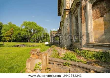 Old magnate palace in ruins, in the park, in spring under the blue sky.A picturesque building in a beautiful park in late May at the height of spring.