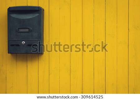 Old mailbox on a yellow wooden background, rustic style