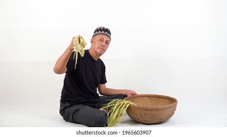 The Old Malay Man Weaving Ketupat Coconut Leaf. Ketupat Is The Traditional Food Of Malaysia During The Hari Raya Festival. It Is Made Of Palm Leaves And A Bit Of Rice Included In It.

