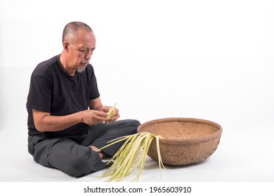 The Old Malay Man Weaving Ketupat Coconut Leaf. Ketupat Is The Traditional Food Of Malaysia During The Hari Raya Festival. It Is Made Of Palm Leaves And A Bit Of Rice Included In It.

