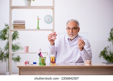 Old Male Dentist Working In The Clinic