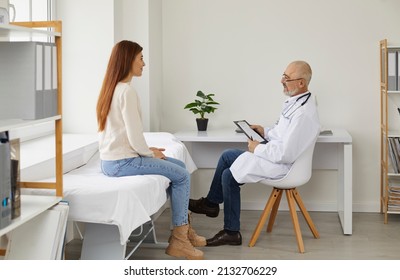 Old male doctor consult female patient in hospital. Senior man GP or therapist talk with woman client at appointment in private clinic. Good medical service. Healthcare and medicine.