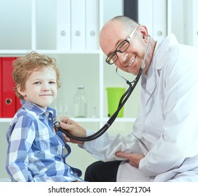 Old Male Doctor Examining A Child Patient By  Stethoscope. Health Care Concept.