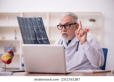 Old male doctor radiologist working in the clinic - Shutterstock ID 2311761387