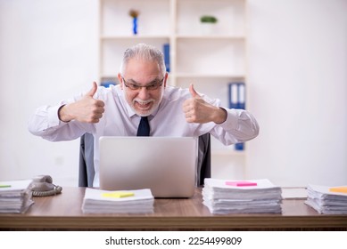 Old male employee and too much work in the office - Shutterstock ID 2254499809
