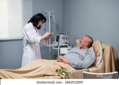An Old Male Patient Lying In A Hospital Bed Wearing Pyjamas, A Nurse With A Clipboard Is Examining Him And Making Notes.