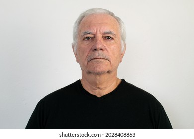 old male senior black shirt closeup white wall background sad unhappy depression face expression frowning looking no emotion retired