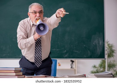 Old Male Teacher In The Classroom