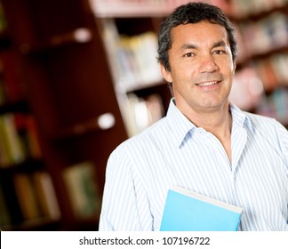 Old male university student smiling at the library