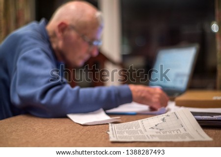 Old man of 93 using his laptop to check his finances online,very challenging for old people.