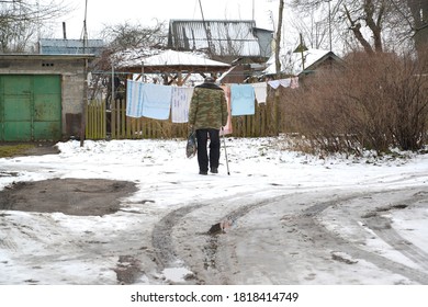 An Old Man Approaches A Stripped-down Belly Hung On A Rope. City Pioneerskij, Kaliningrad Region